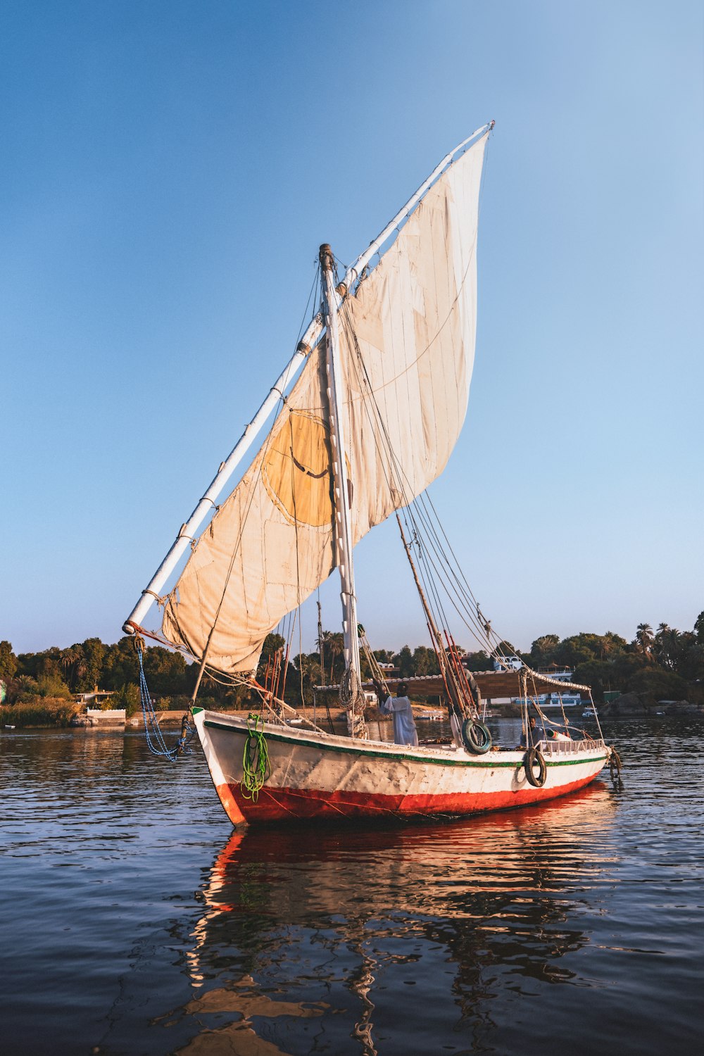 a sailboat with a white sail is in the water