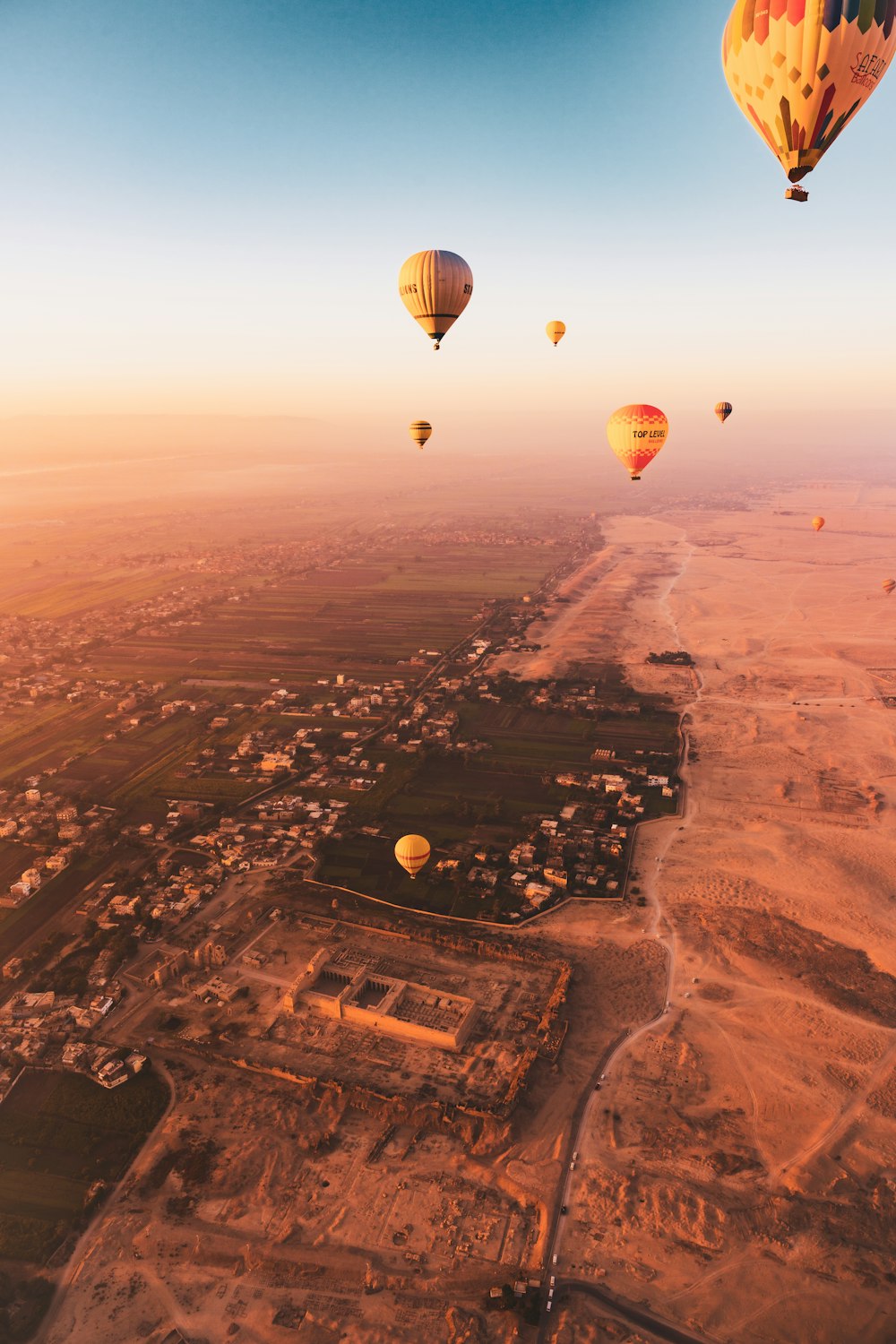 um grupo de balões de ar quente sobrevoando uma cidade