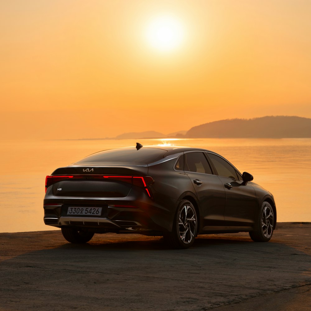 a car parked on the beach at sunset