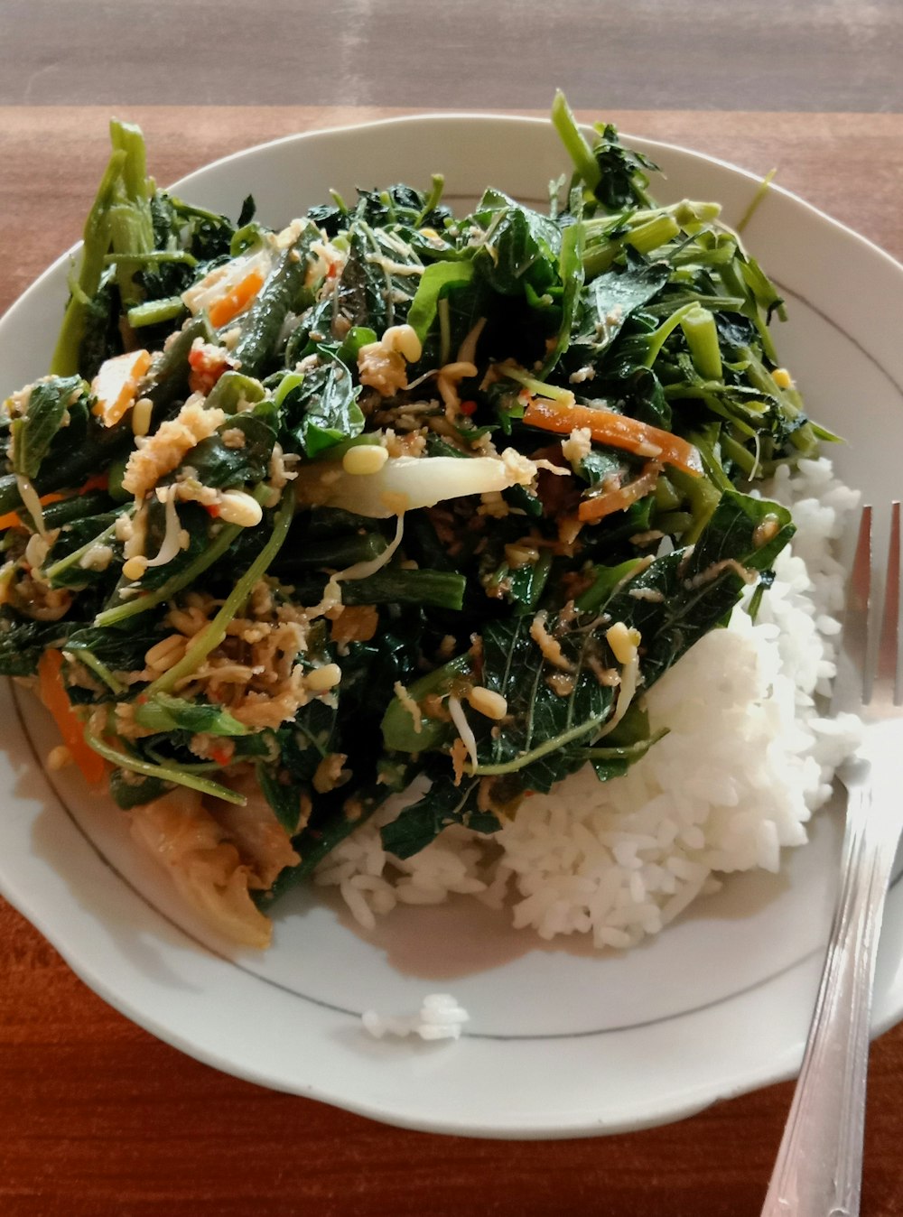 a white plate topped with rice and greens