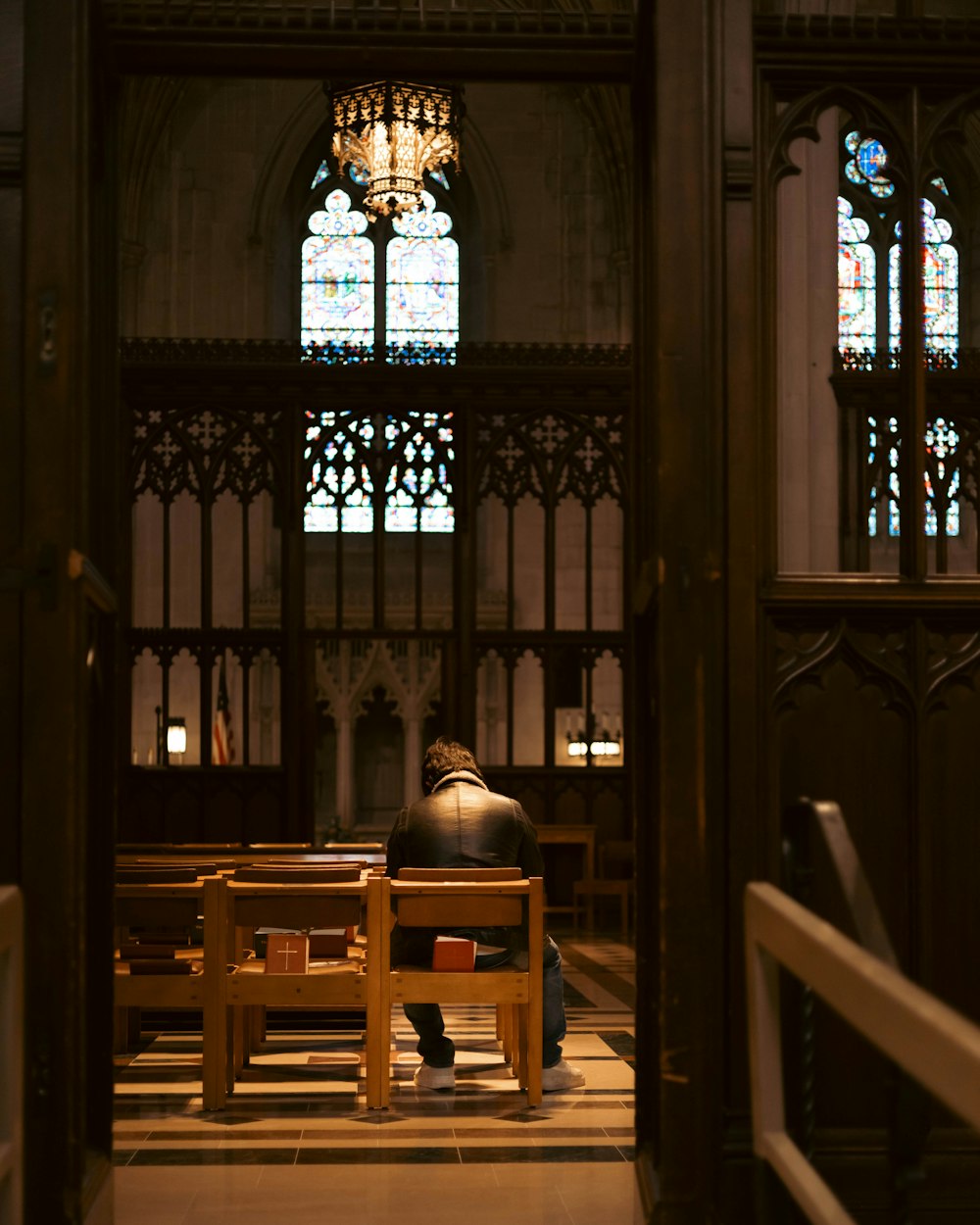 a person sitting on a bench in a church