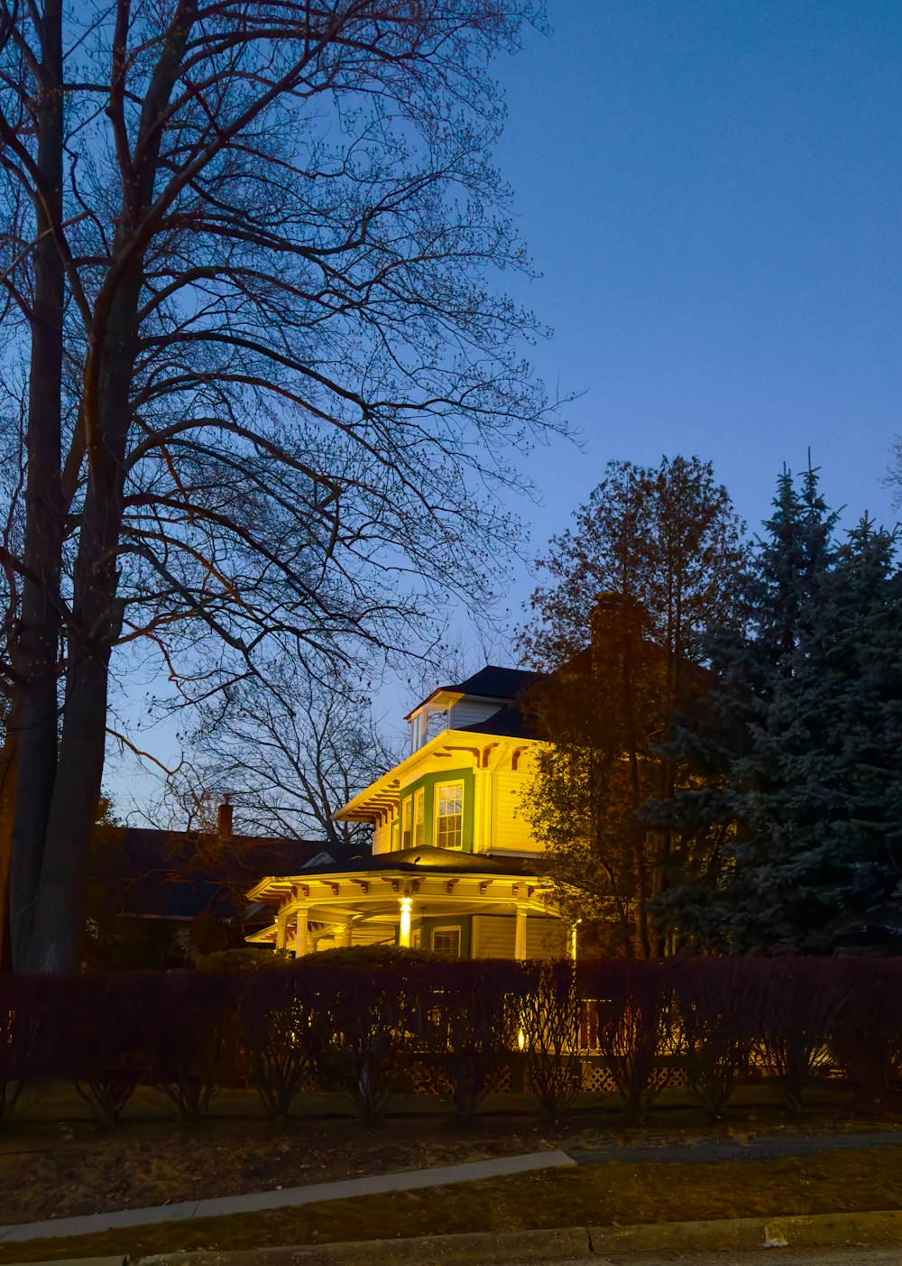 a large yellow house with a clock on the front of it