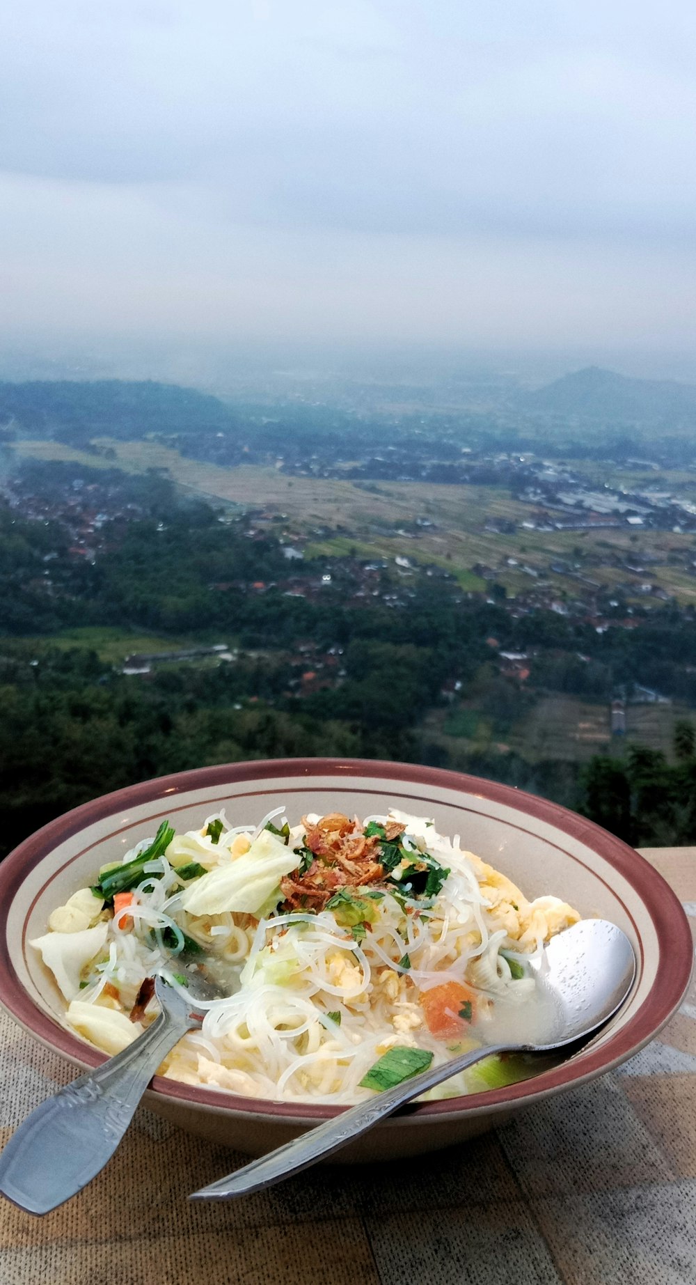 a bowl of food on a table with a view of a valley