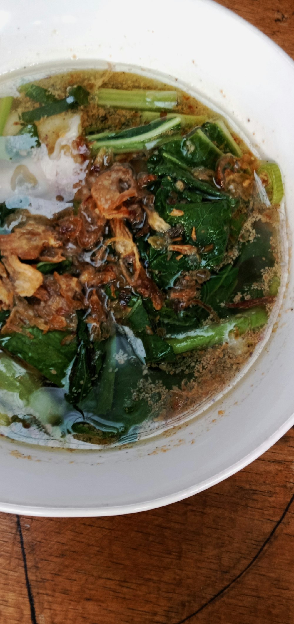 a white bowl filled with soup on top of a wooden table