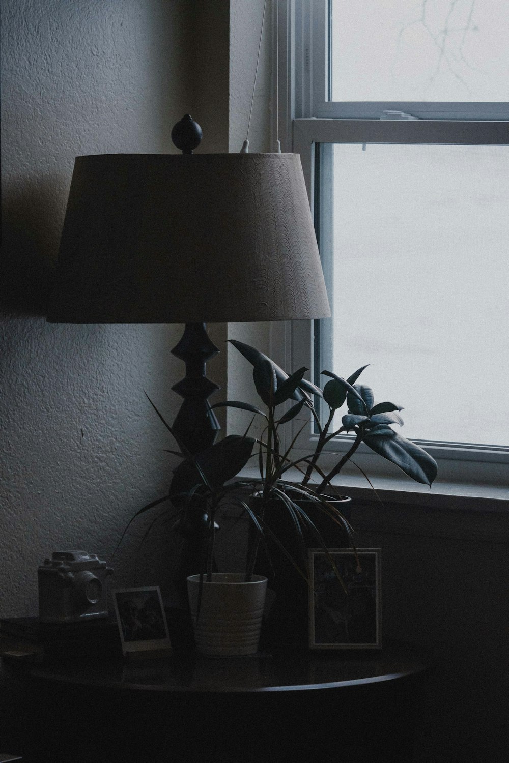 a lamp sitting on top of a table next to a window