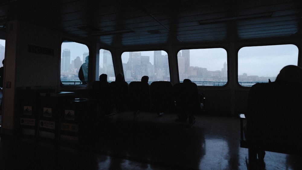 a group of people sitting in a boat looking out the window