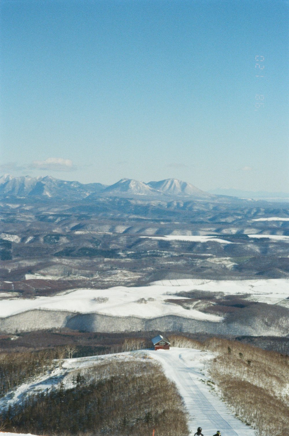 a couple of people riding skis on top of a snow covered slope