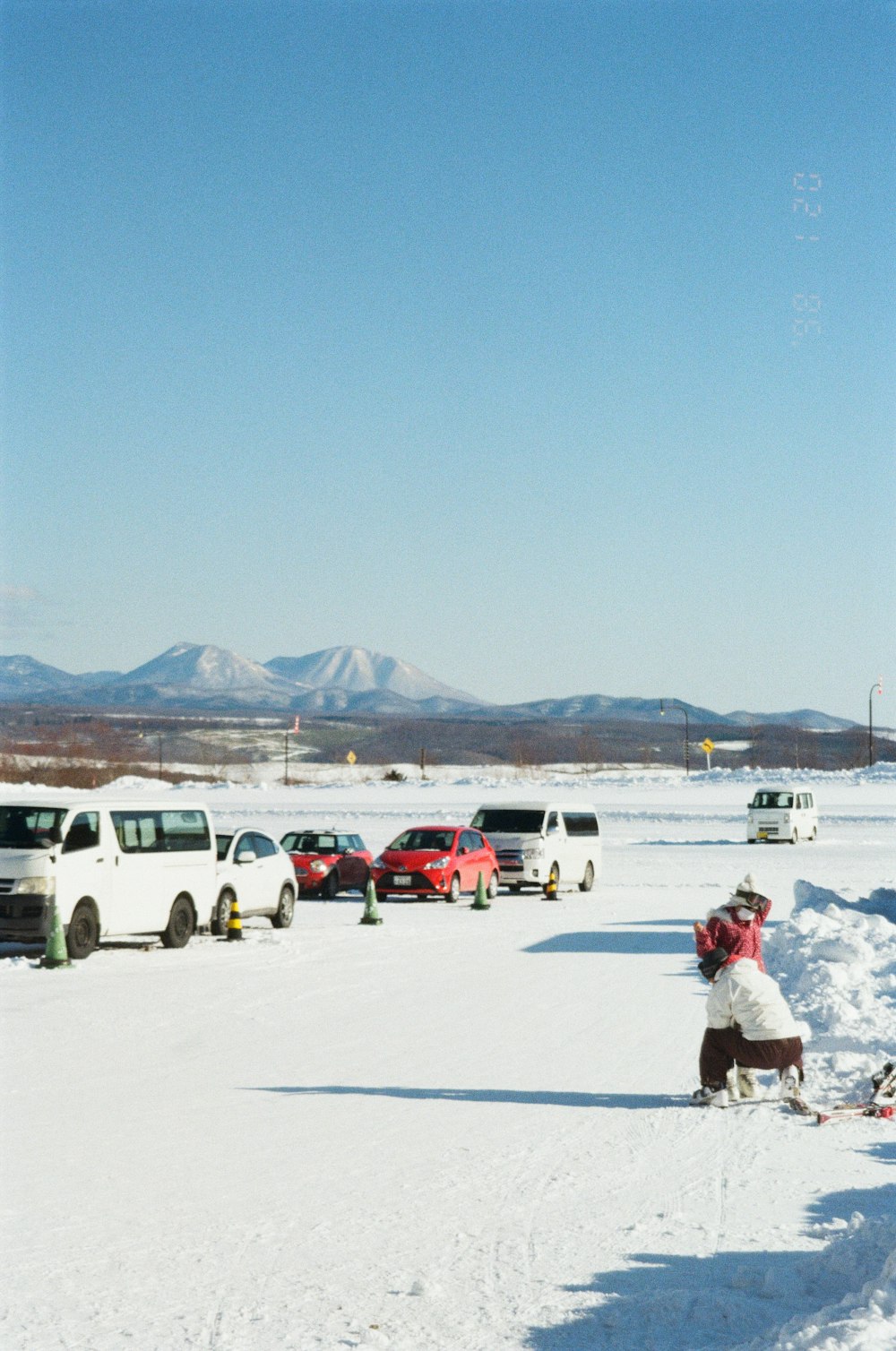 a group of cars parked in a parking lot covered in snow