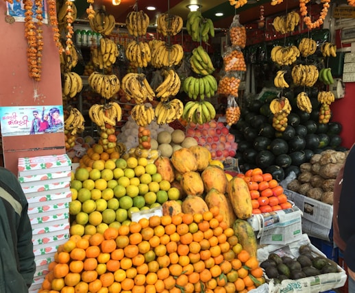 a man standing in front of a fruit stand