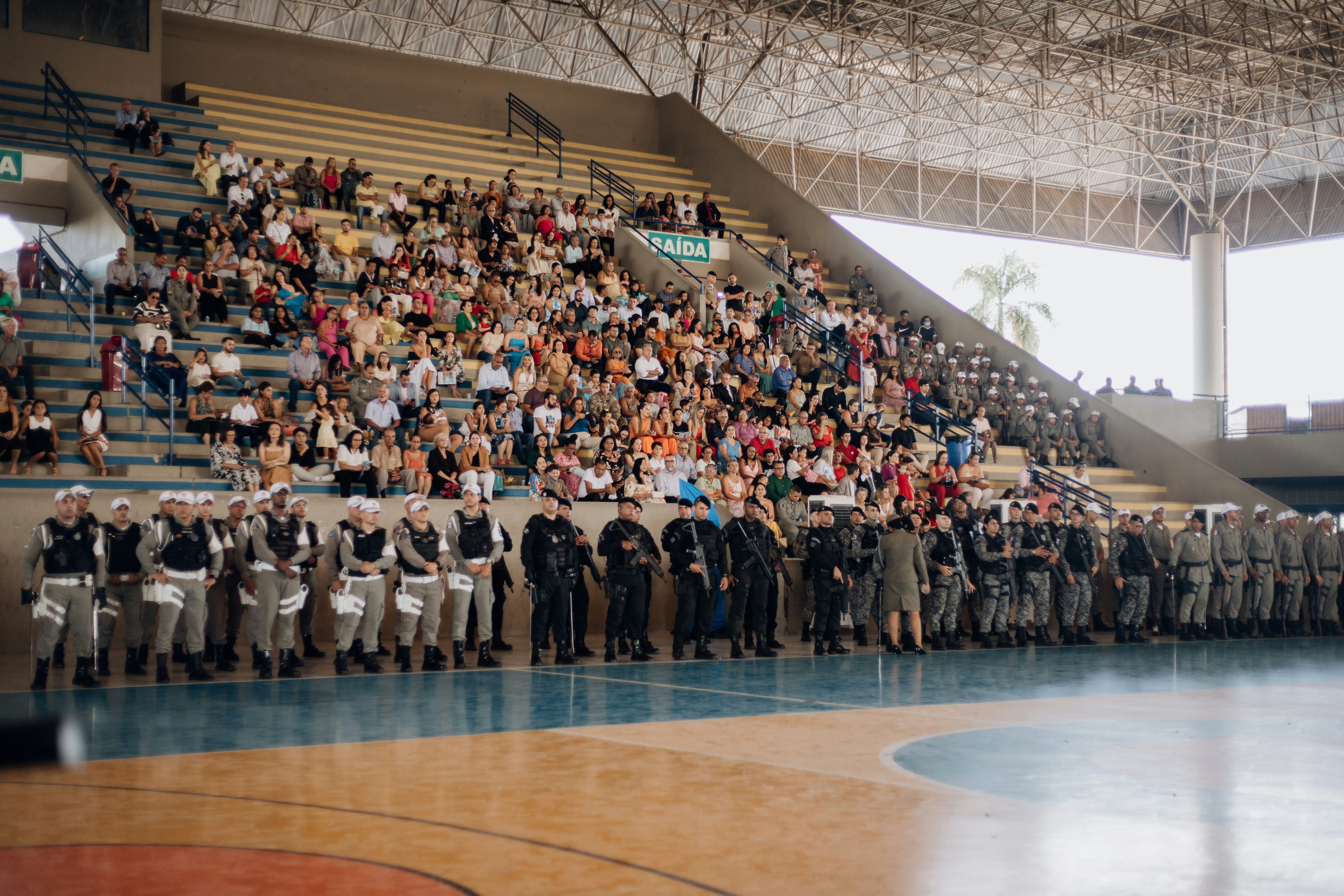 a large group of people standing in front of a basketball court