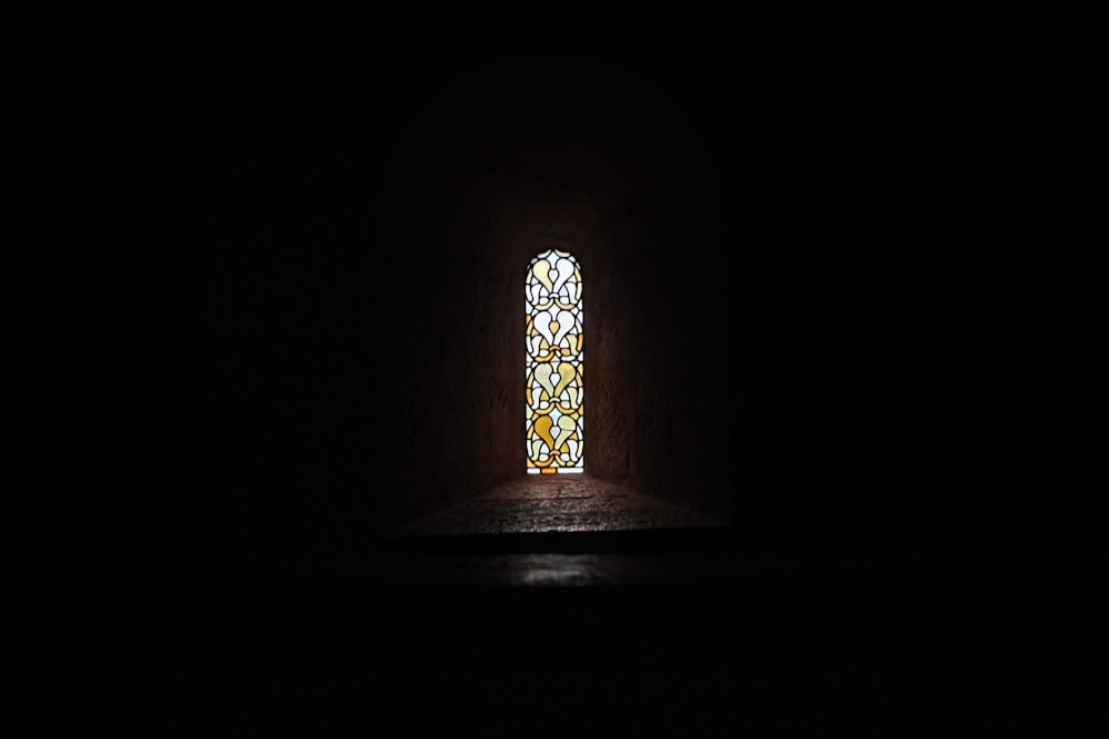 a stained glass window in a dark room