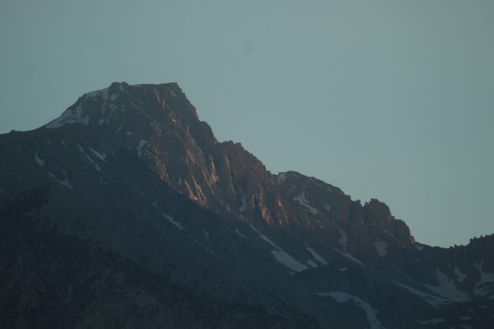 a very tall mountain with snow on it's sides