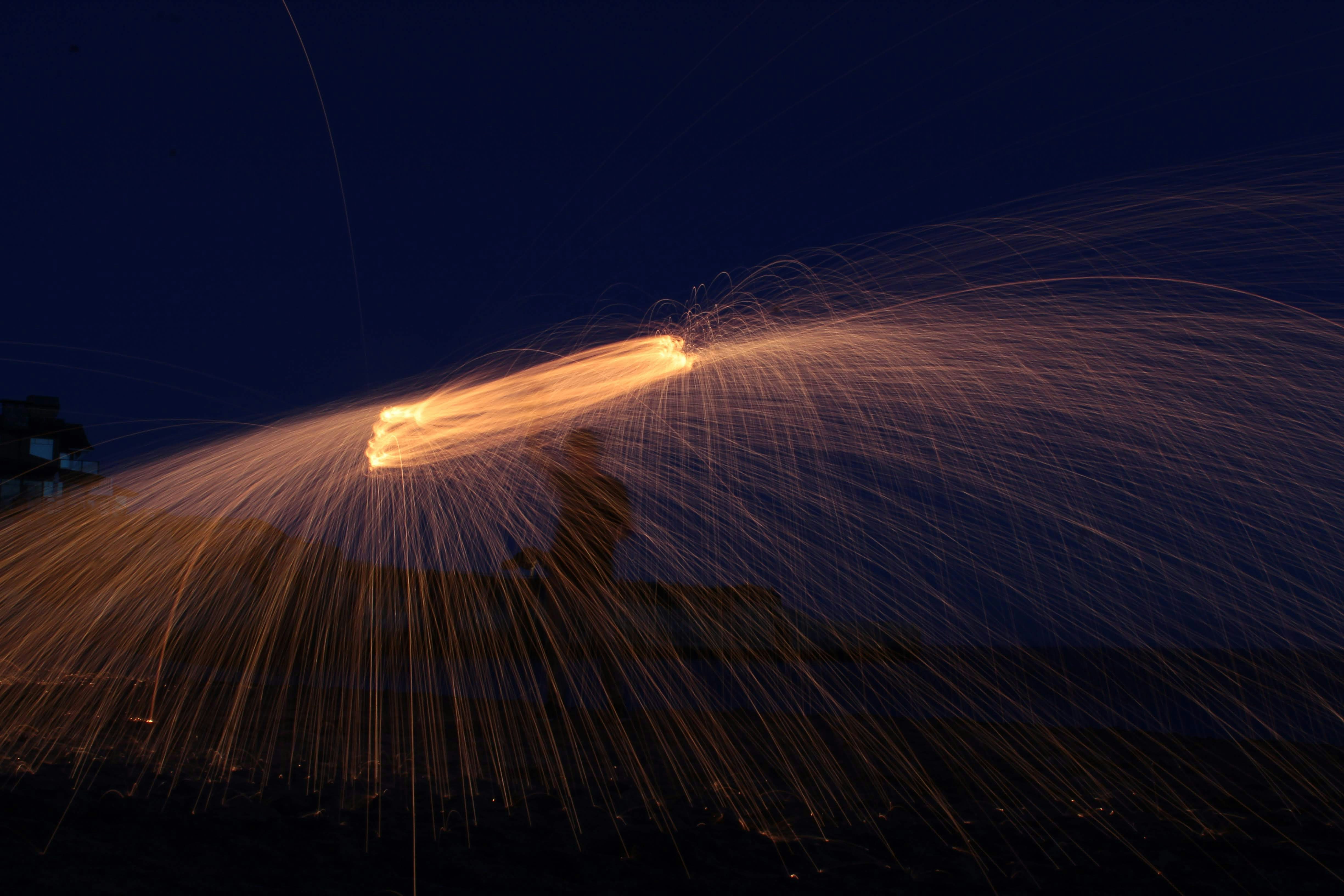a long exposure photo of a firework at night