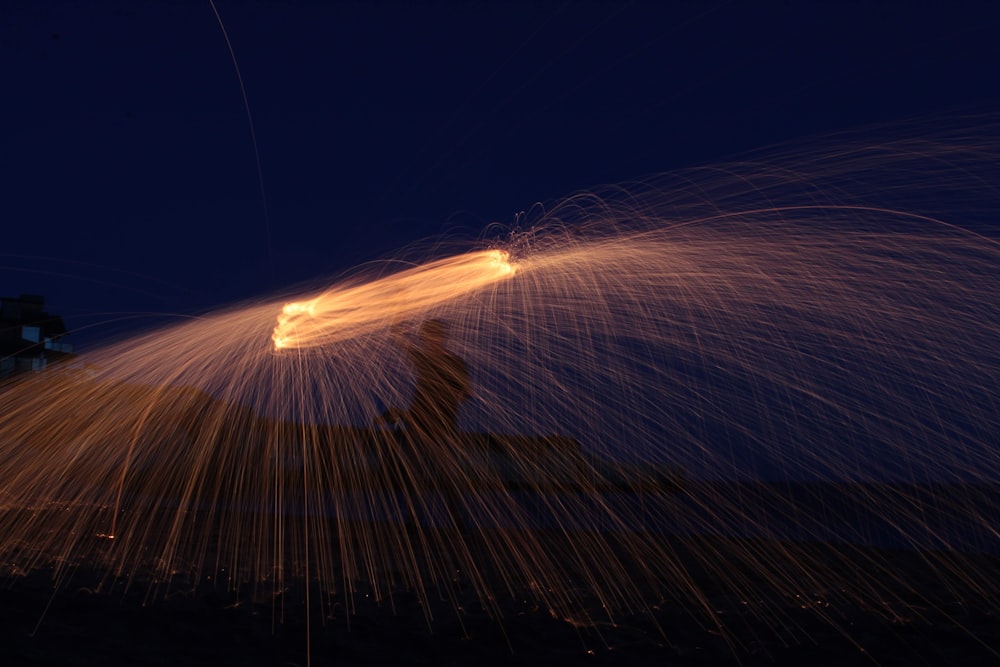 a long exposure photo of a firework at night