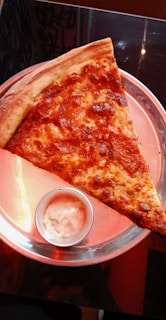 a slice of pizza on a pink plate