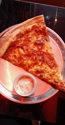 a slice of pizza on a pink plate