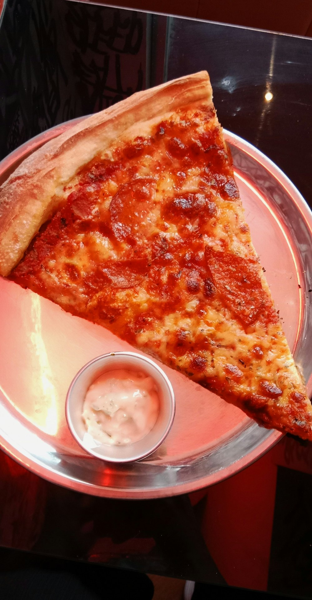 a slice of pizza on a pink plate