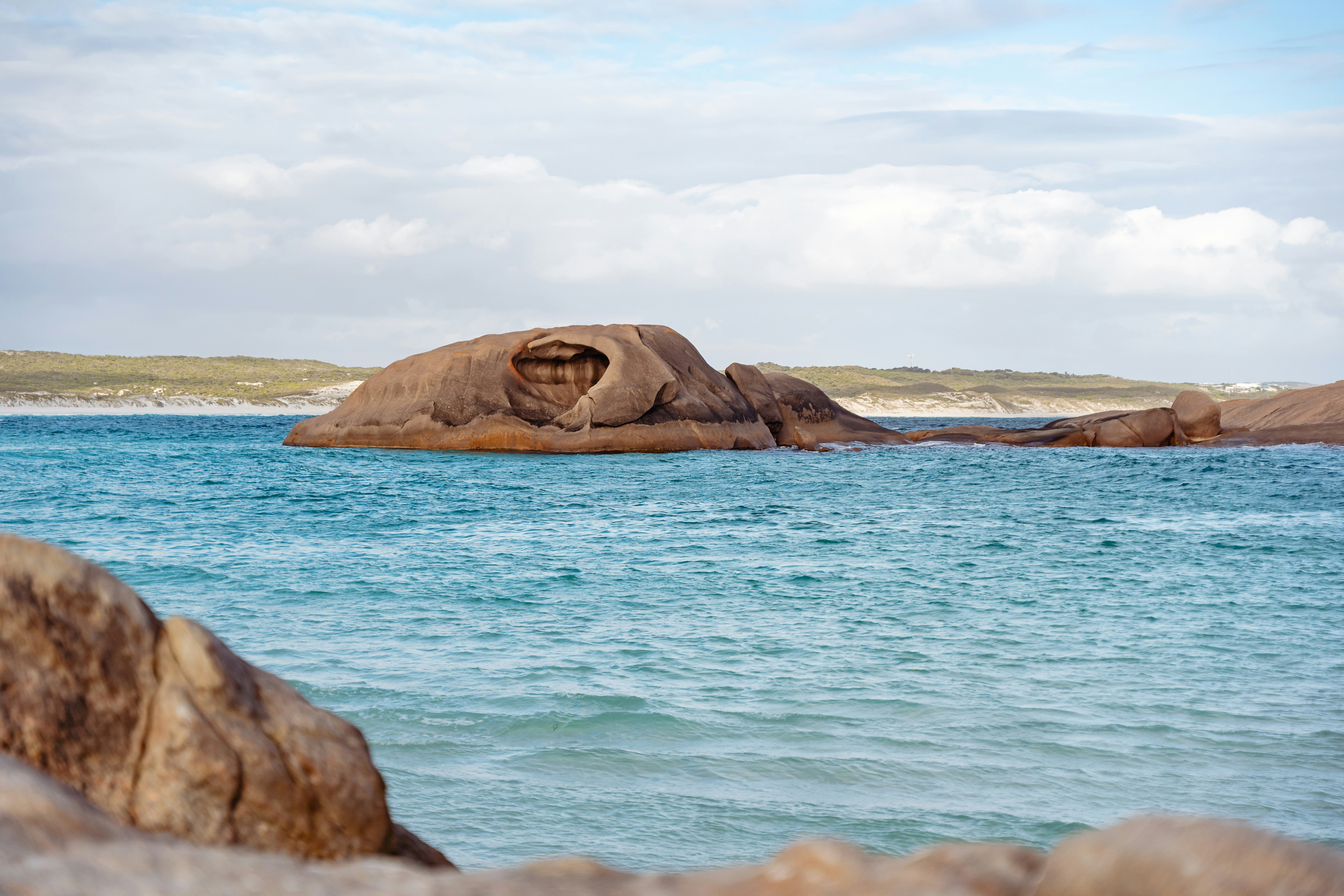 a large rock in the middle of a body of water