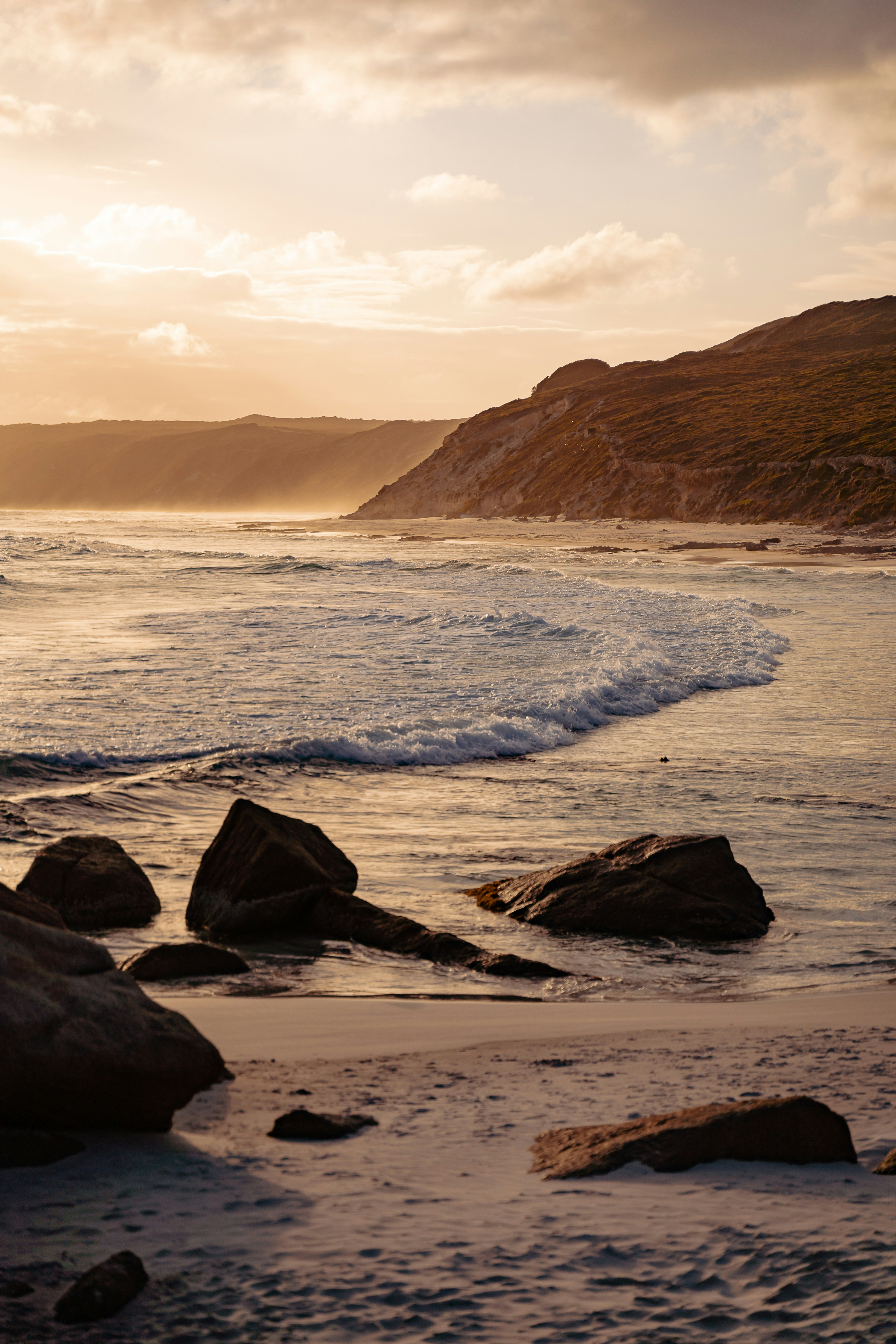 a person walking on a beach with a surfboard