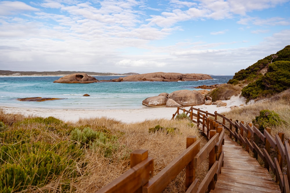 a wooden path leading to a sandy beach