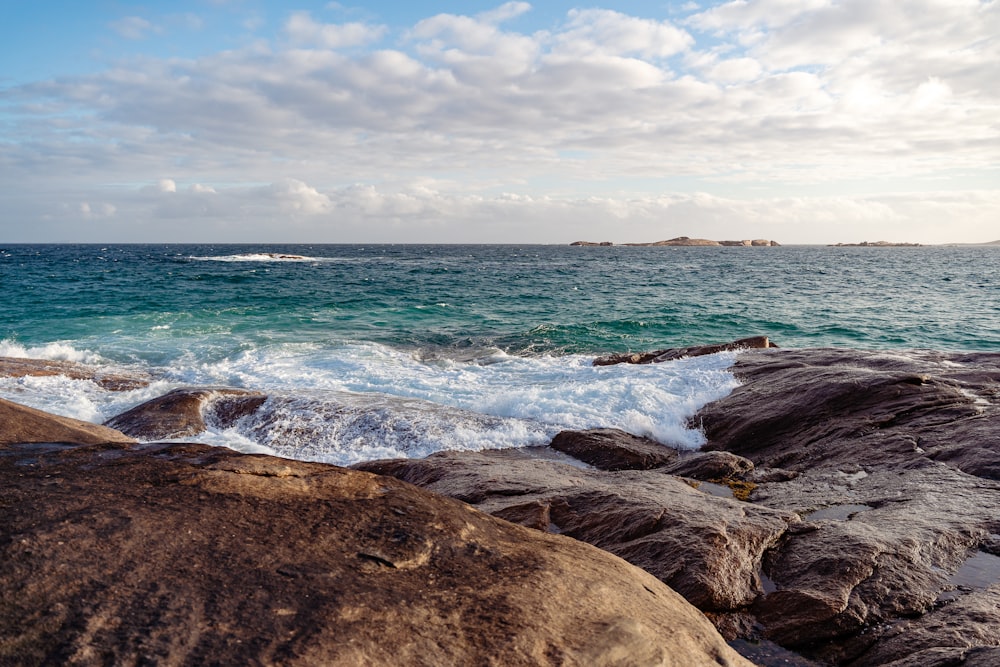 a view of the ocean from a rocky shore