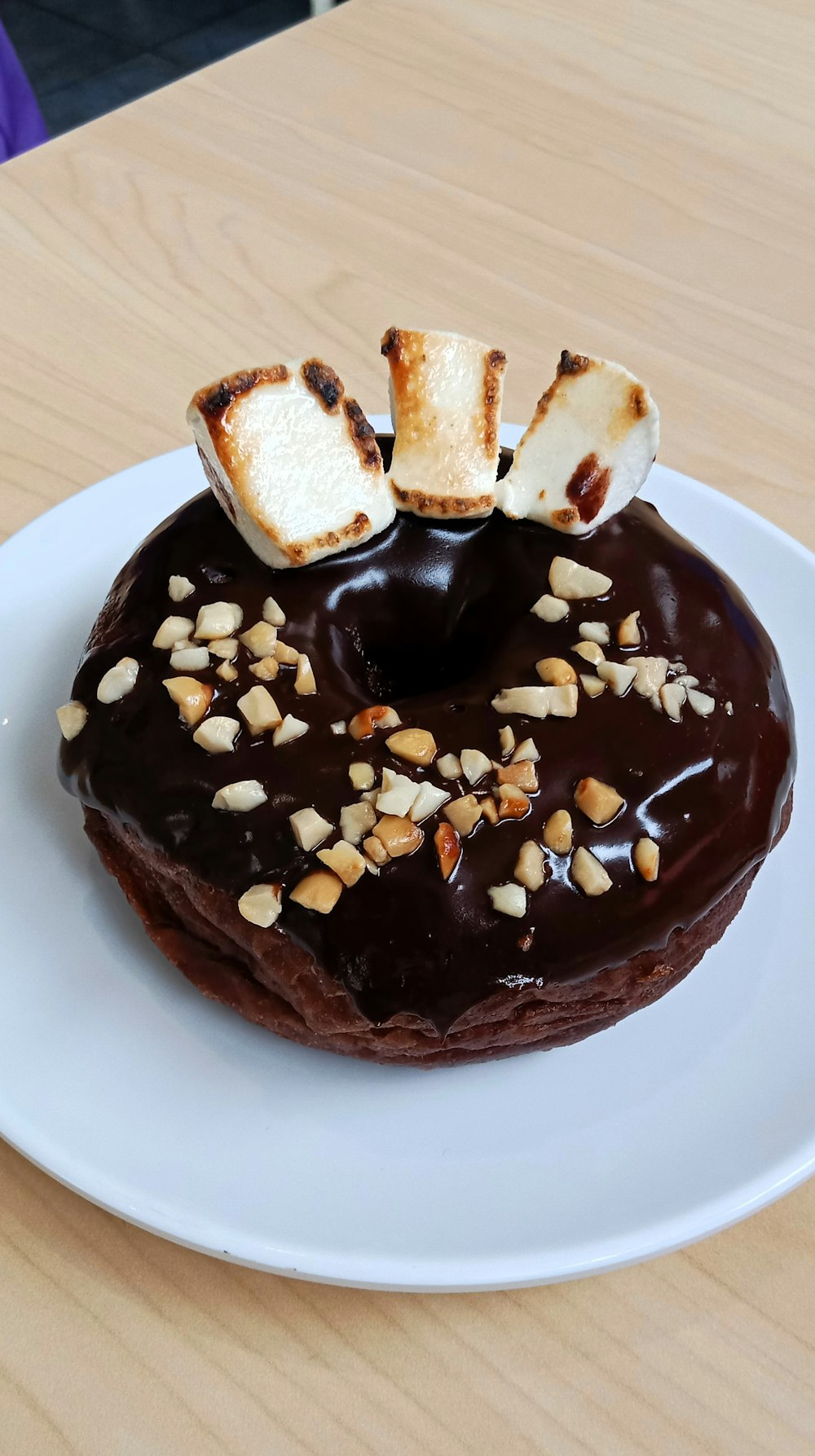 um donut de chocolate com marshmallows por cima