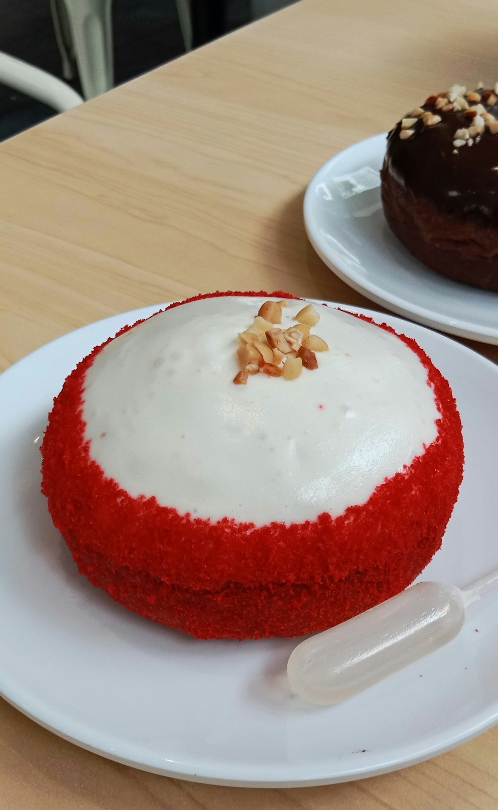 Un pastel de terciopelo rojo con glaseado blanco y nueces encima