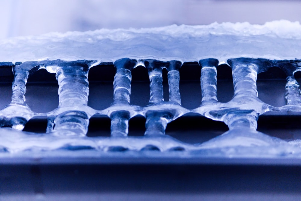 a close up of a metal grate with snow on it