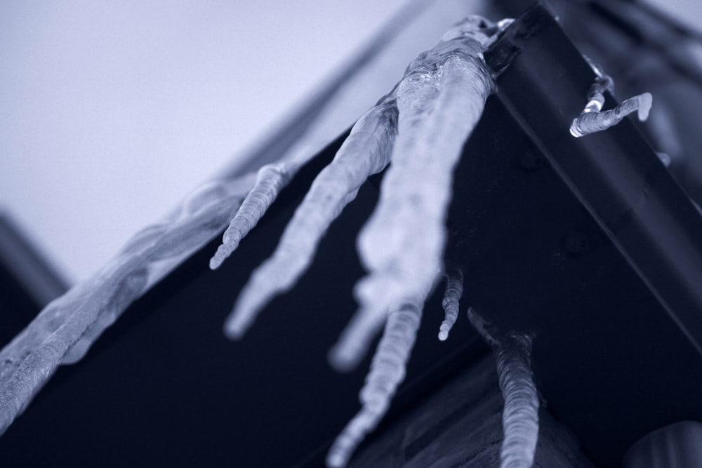 a black and white photo of a hand hanging from a building