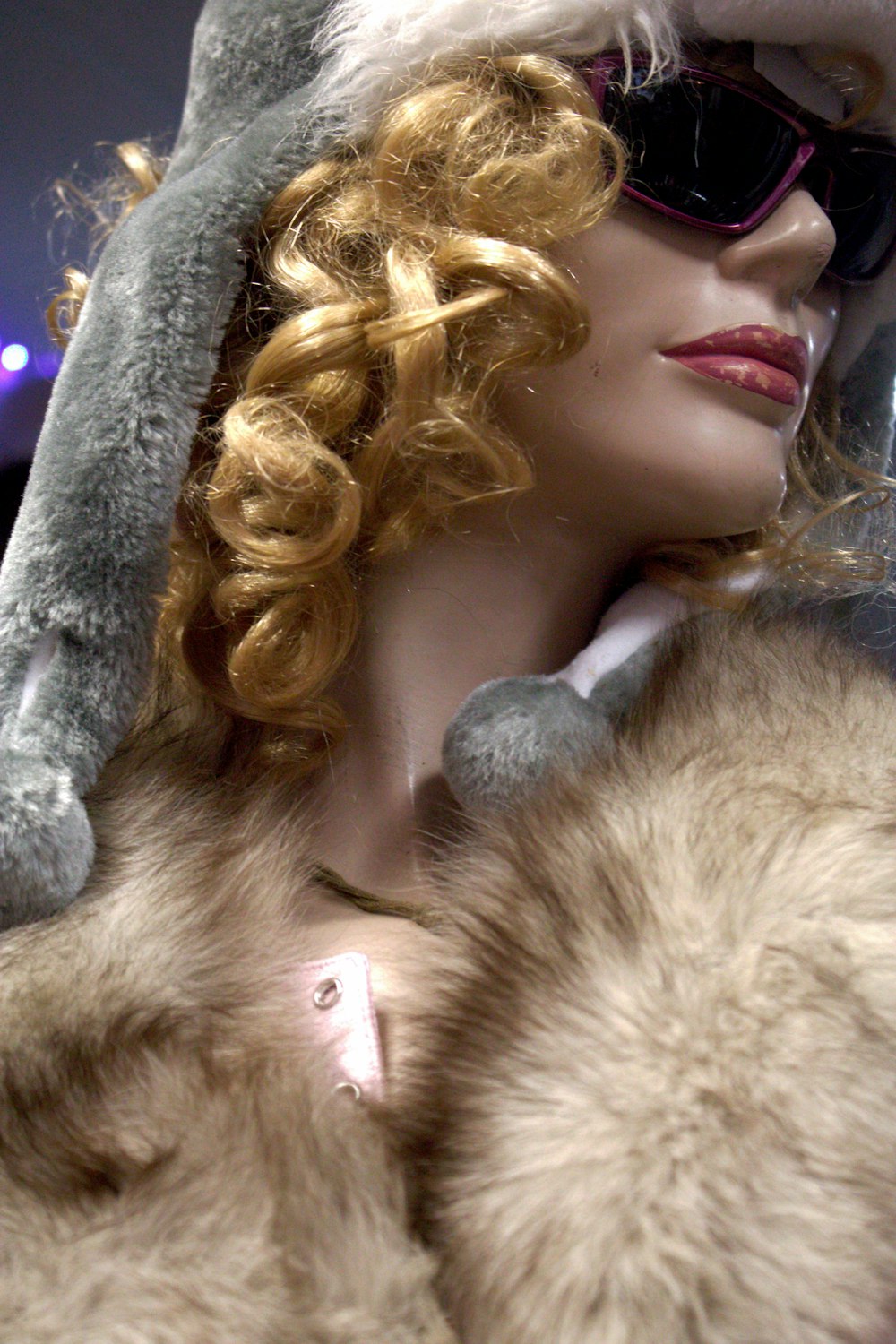 a mannequin wearing a fur hat and sunglasses