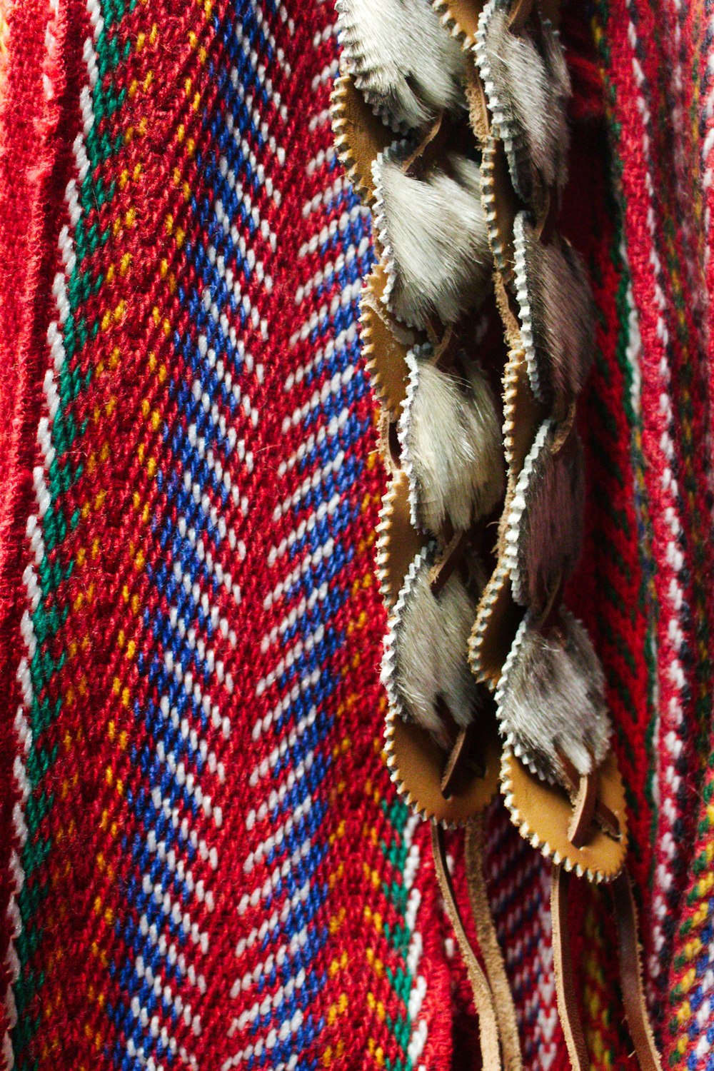 a close up of a knitted blanket with a tassel