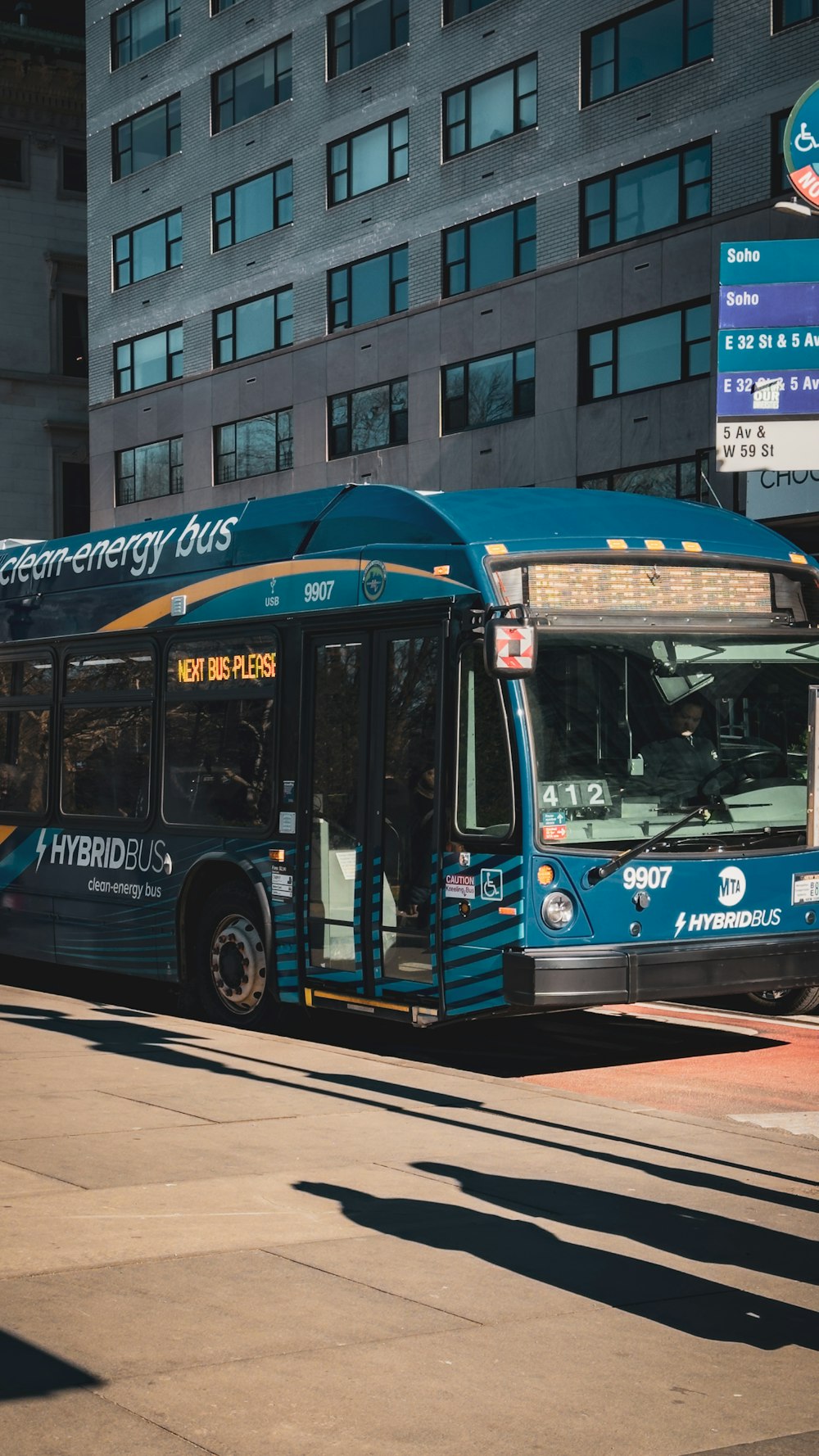 a blue and yellow bus on a city street