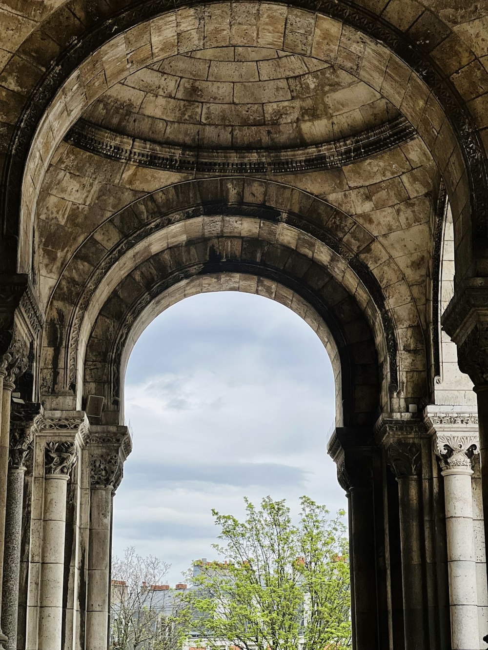 a stone archway with a clock tower in the background