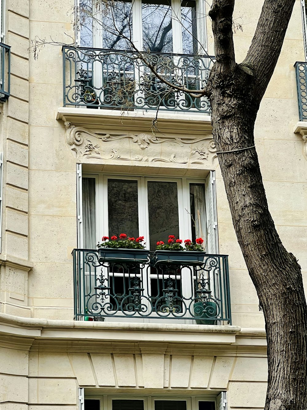 a building with a balcony and a tree in front of it