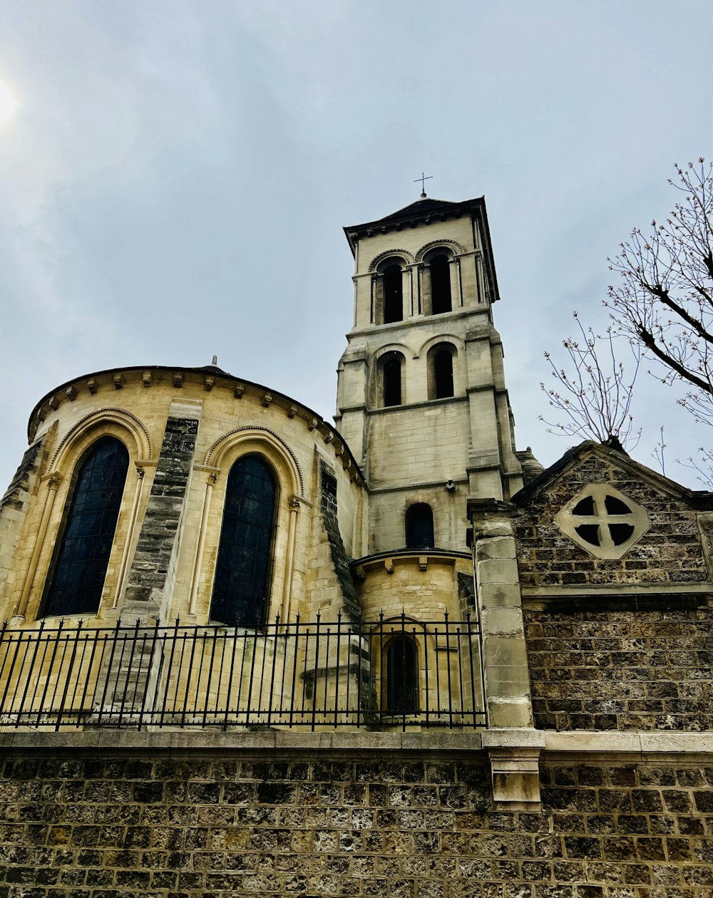 an old church with a steeple and a wrought iron fence