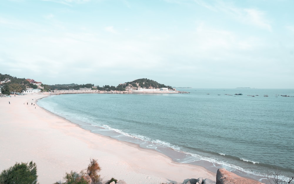 a view of a beach with people walking on it