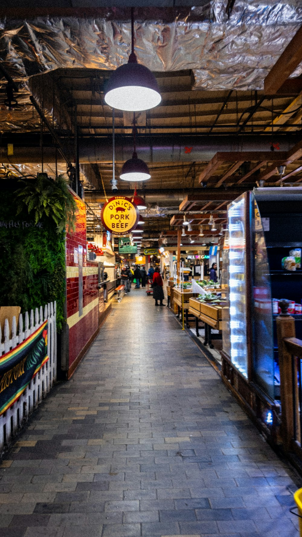 a store with a long brick walkway and lots of produce