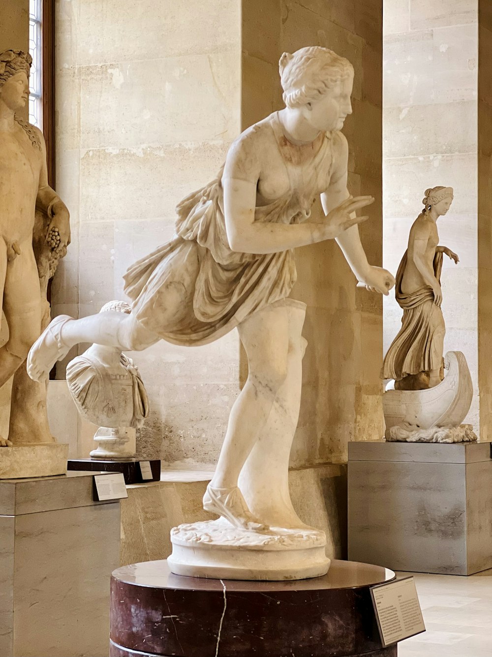 a statue of a woman holding a bird in a museum