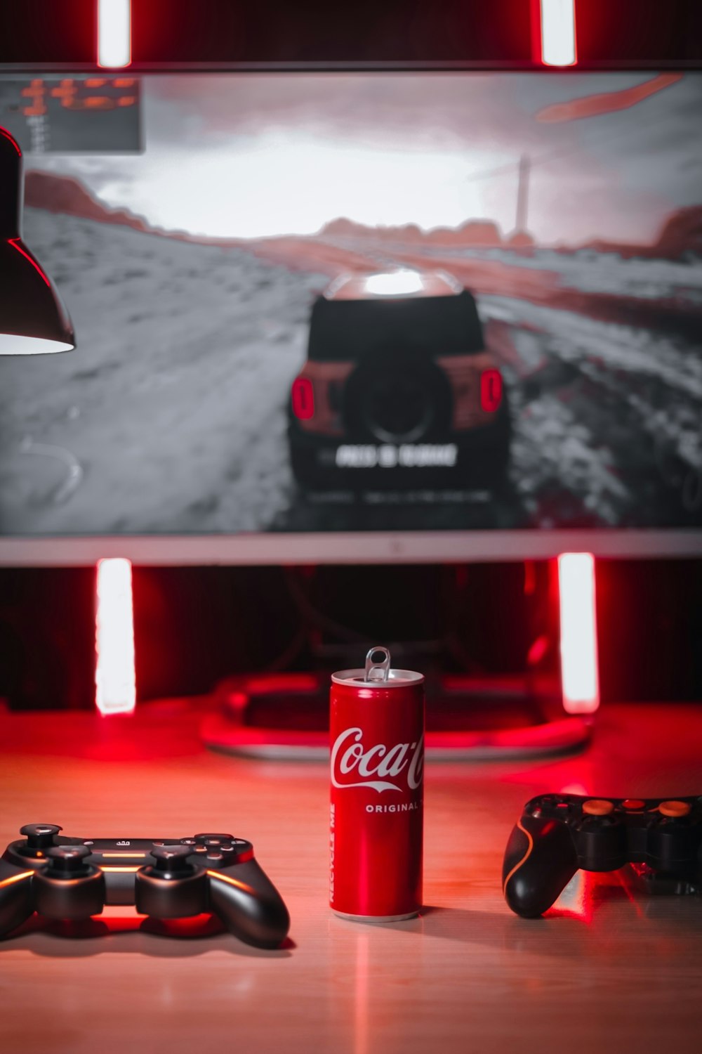 a coca cola can sitting next to a video game controller