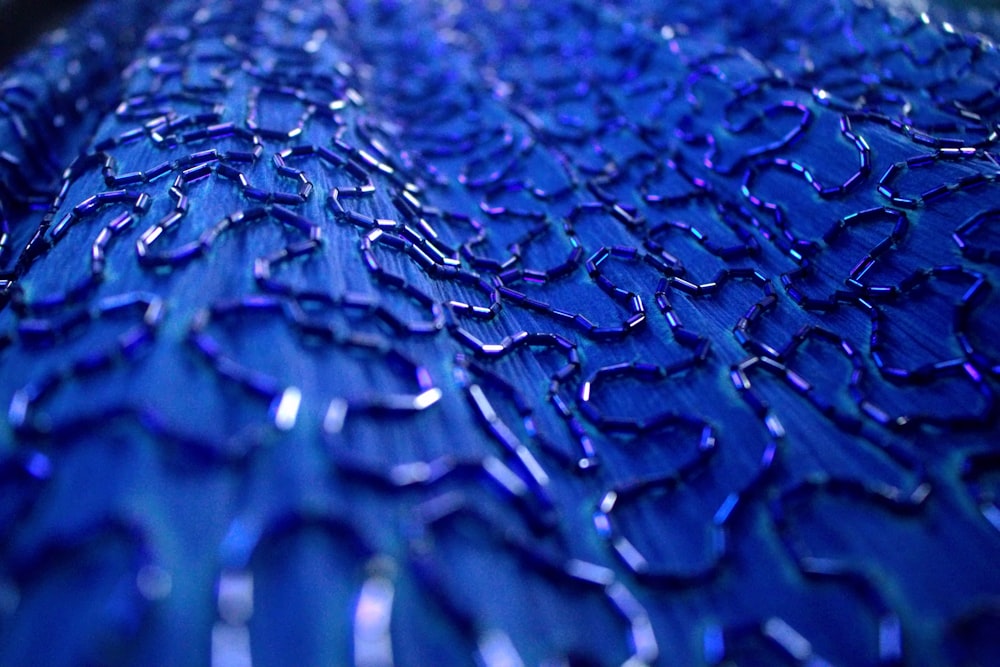 a close up of a blue table cloth with drops of water on it