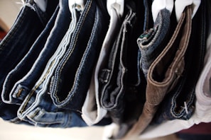 a bunch of jeans hanging on a rack