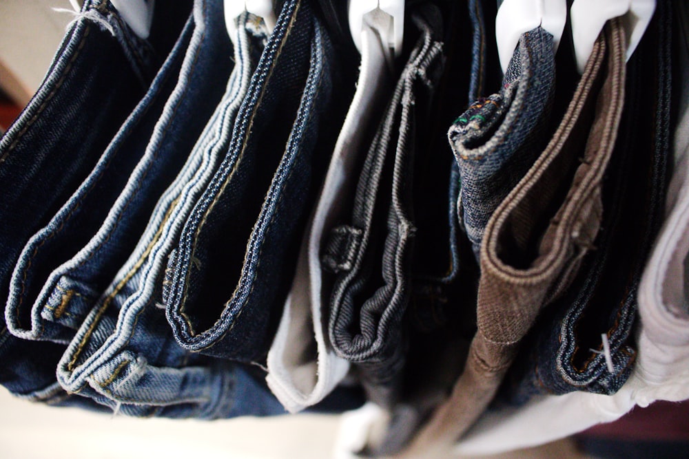a bunch of jeans hanging on a rack