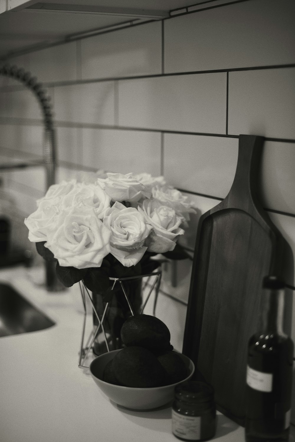 a black and white photo of a vase of roses