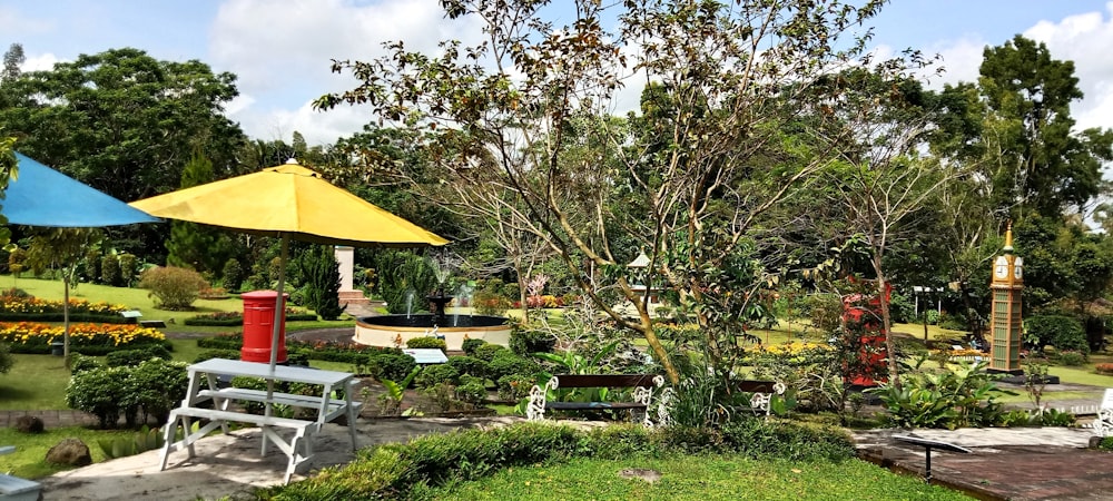 a park with benches, tables, and umbrellas