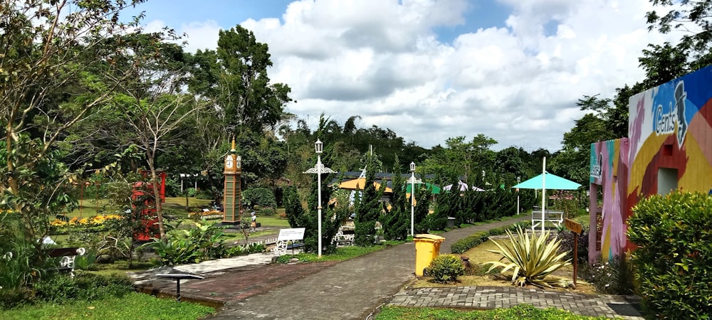 a pathway in a park with lots of trees and plants