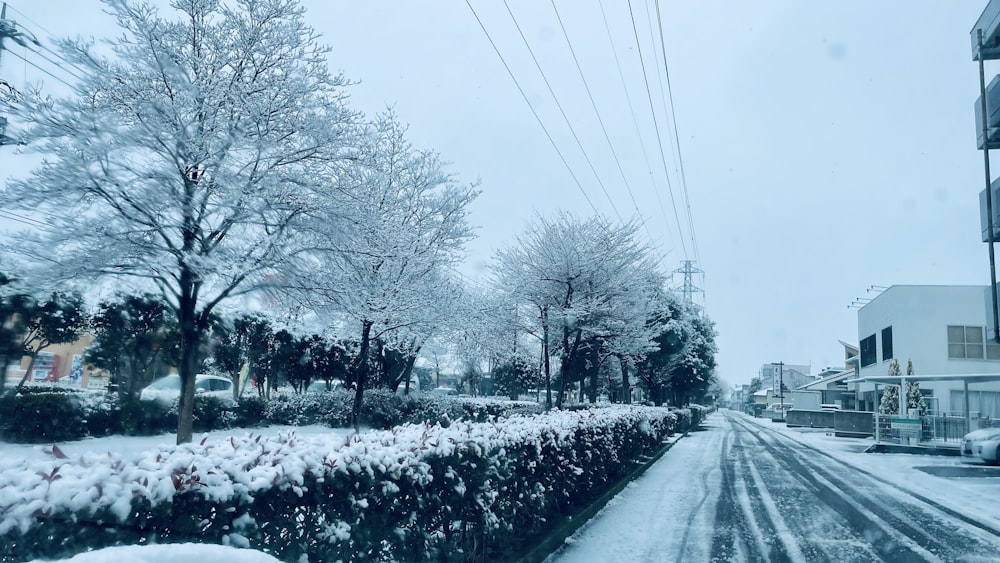 a snow covered street with cars parked on the side of the road