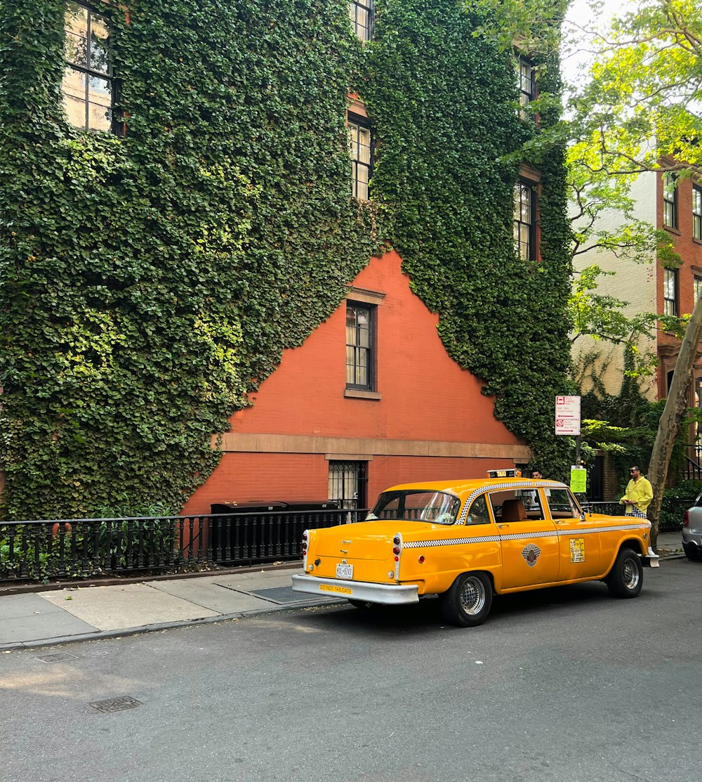 a yellow taxi cab parked in front of a tall building