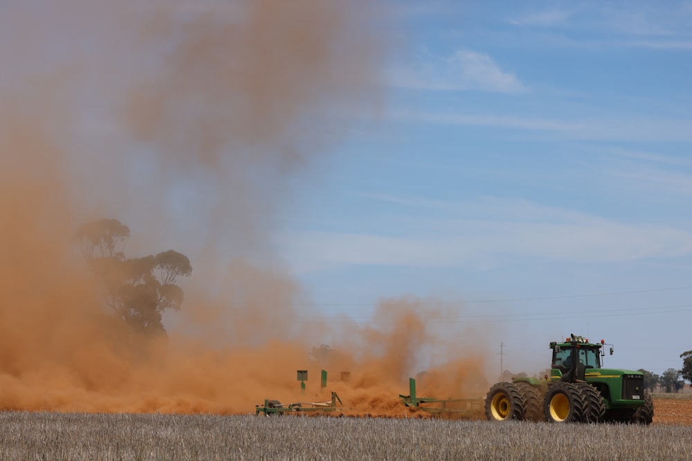 a tractor is plowing a field with dust