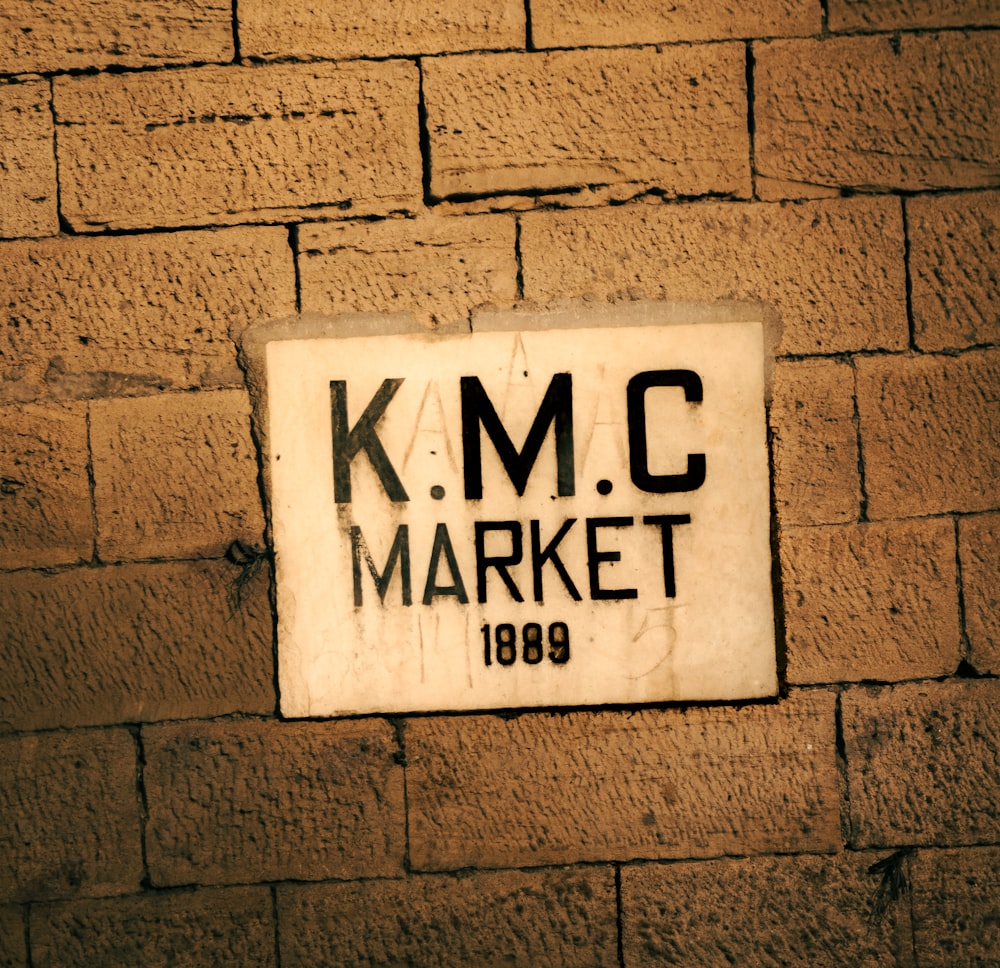 a sign on a brick wall that reads kmc market