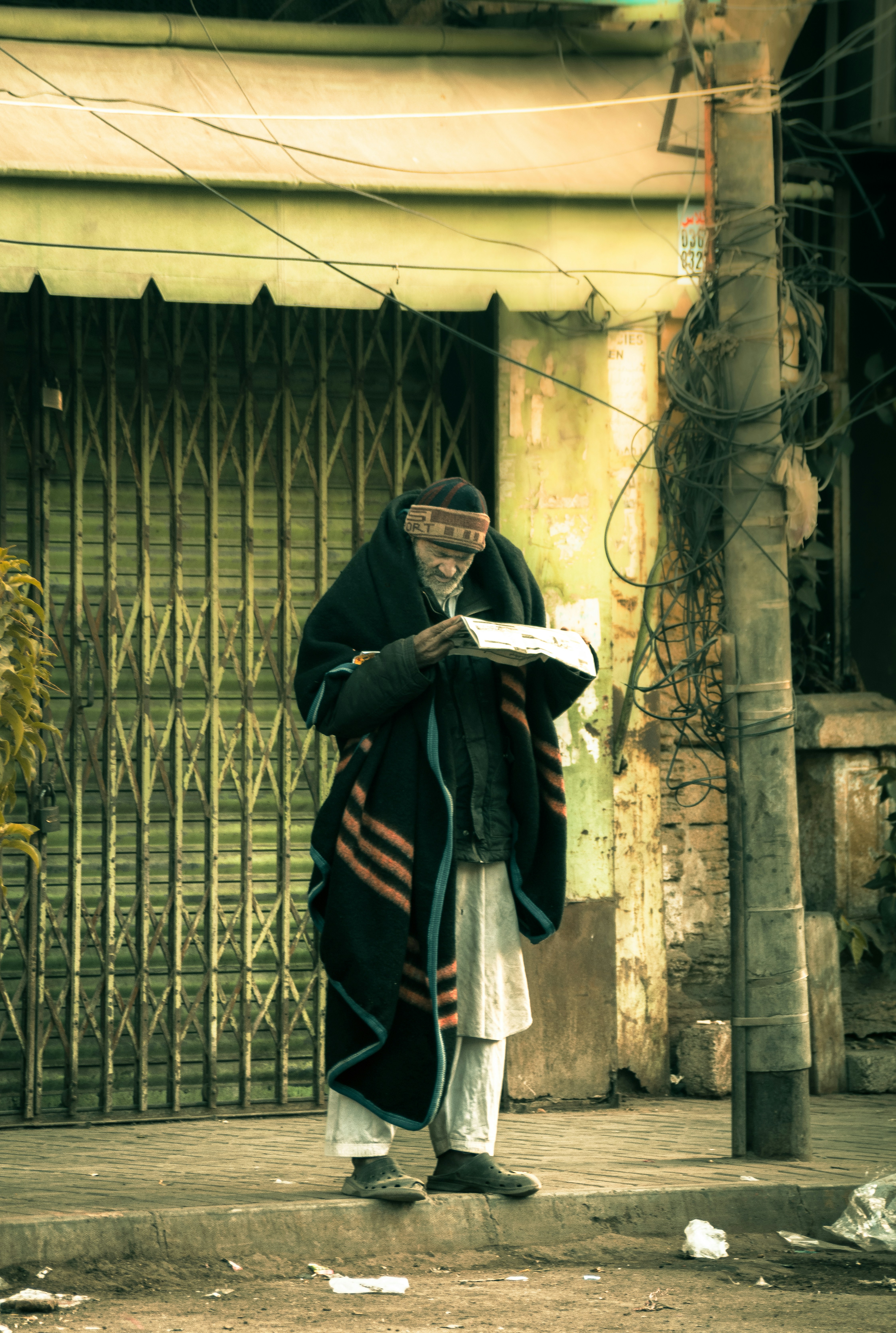 a man standing on the side of a road reading a book